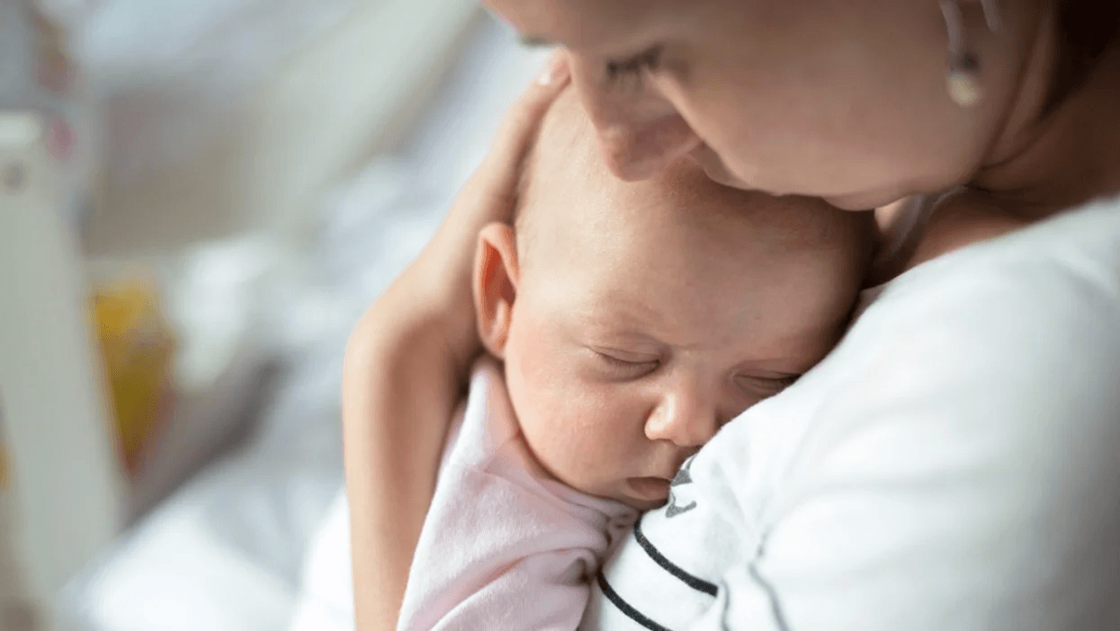 New parents lose 44 days of sleep during the first year of baby’s life mom snuggling sleeping baby under her chin