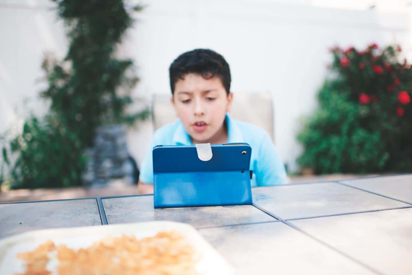 Meet the first FDA-approved video game to treat kids’ ADHD EndeavorRx: young boy playing with ipad outside