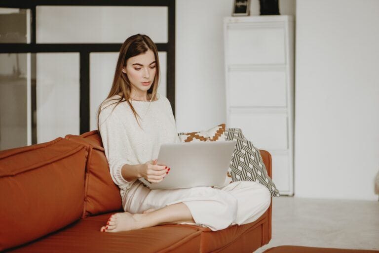 Bookmark these virtual support groups on your TTC journey ttc support groups: woman looking at laptop at home on sofa