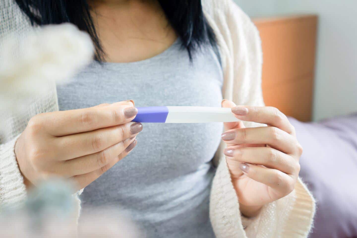 To my friends going through IVF, I’m sorry I didn’t understand IVF struggles: closeup of woman holding pregnancy test