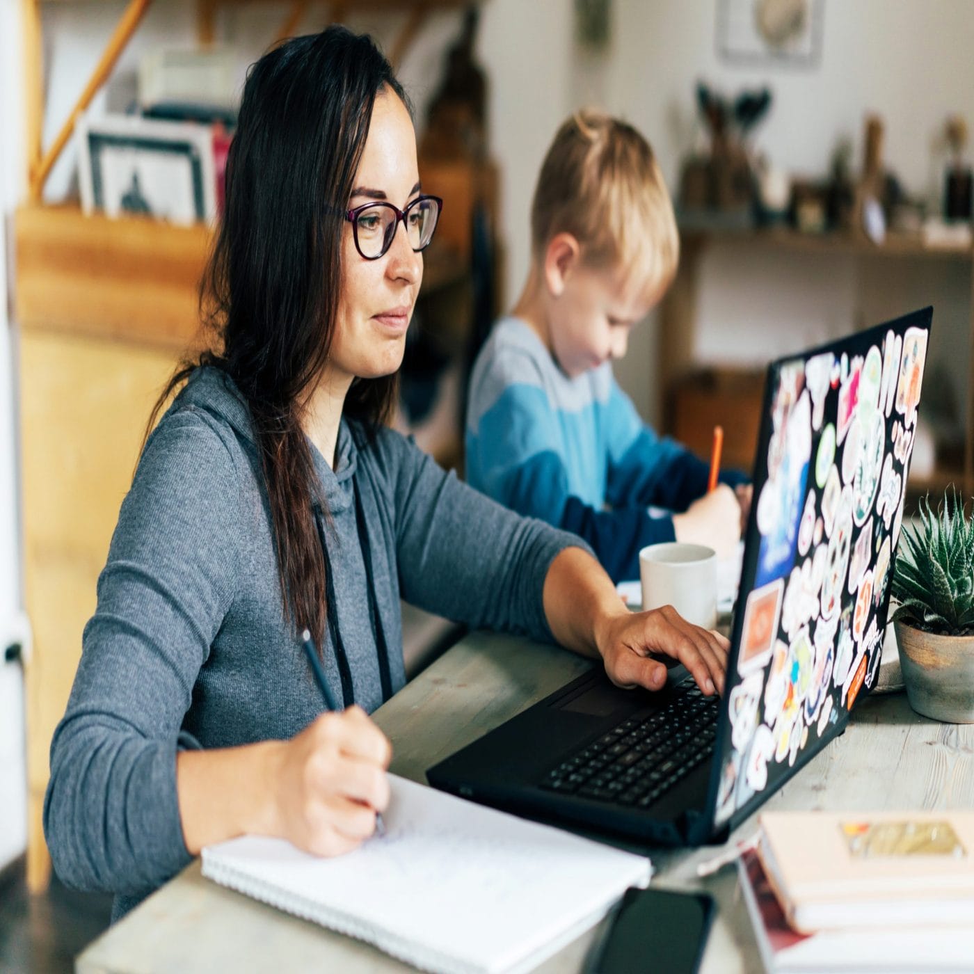 Being a working mom is important to my identity, because building my dream also builds my child’s future working mom: mom on laptop with son sitting by her working on homework