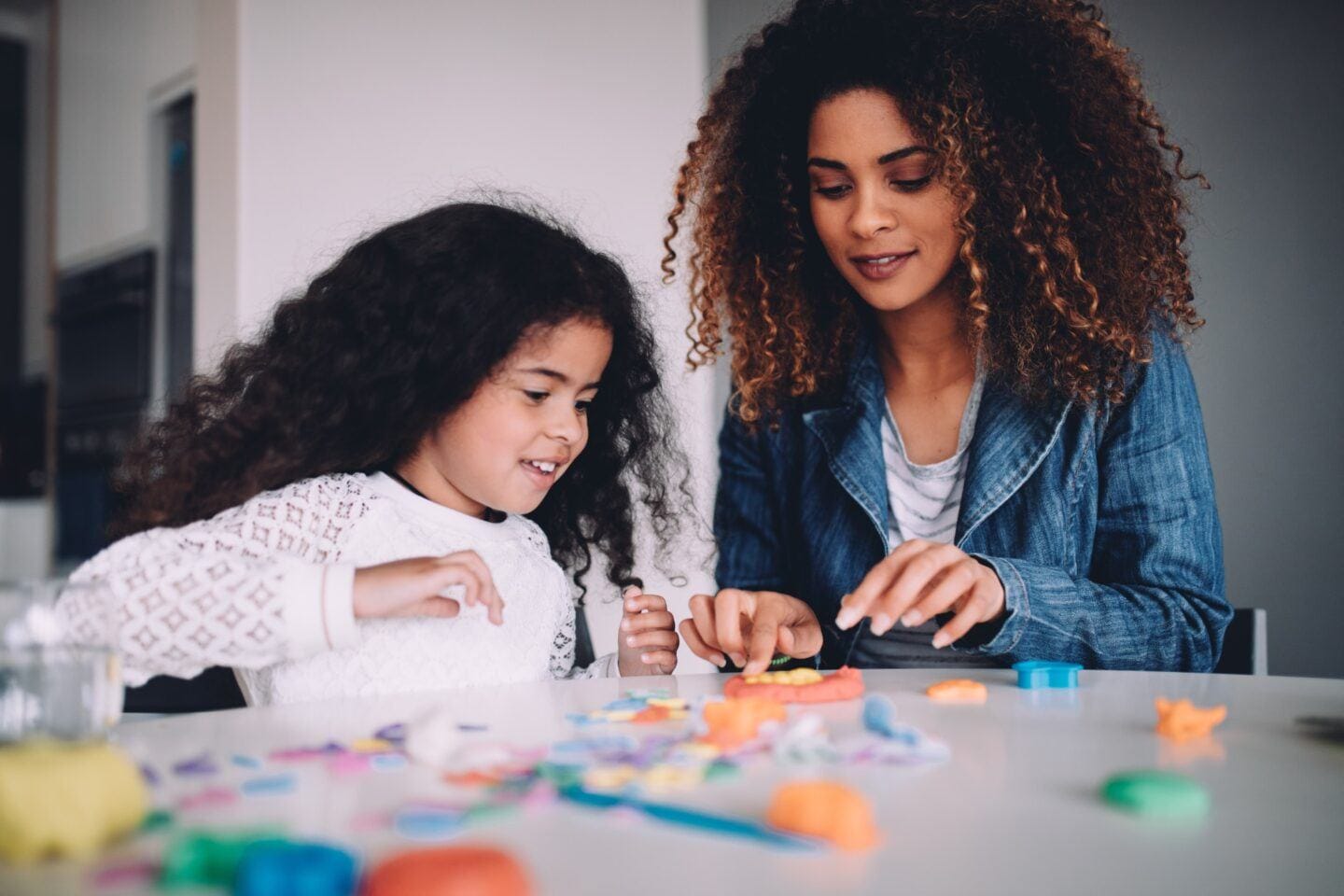 6 ways to raise emotionally intelligent kids, according to a clinical psychologist mom playing with daughter on a table