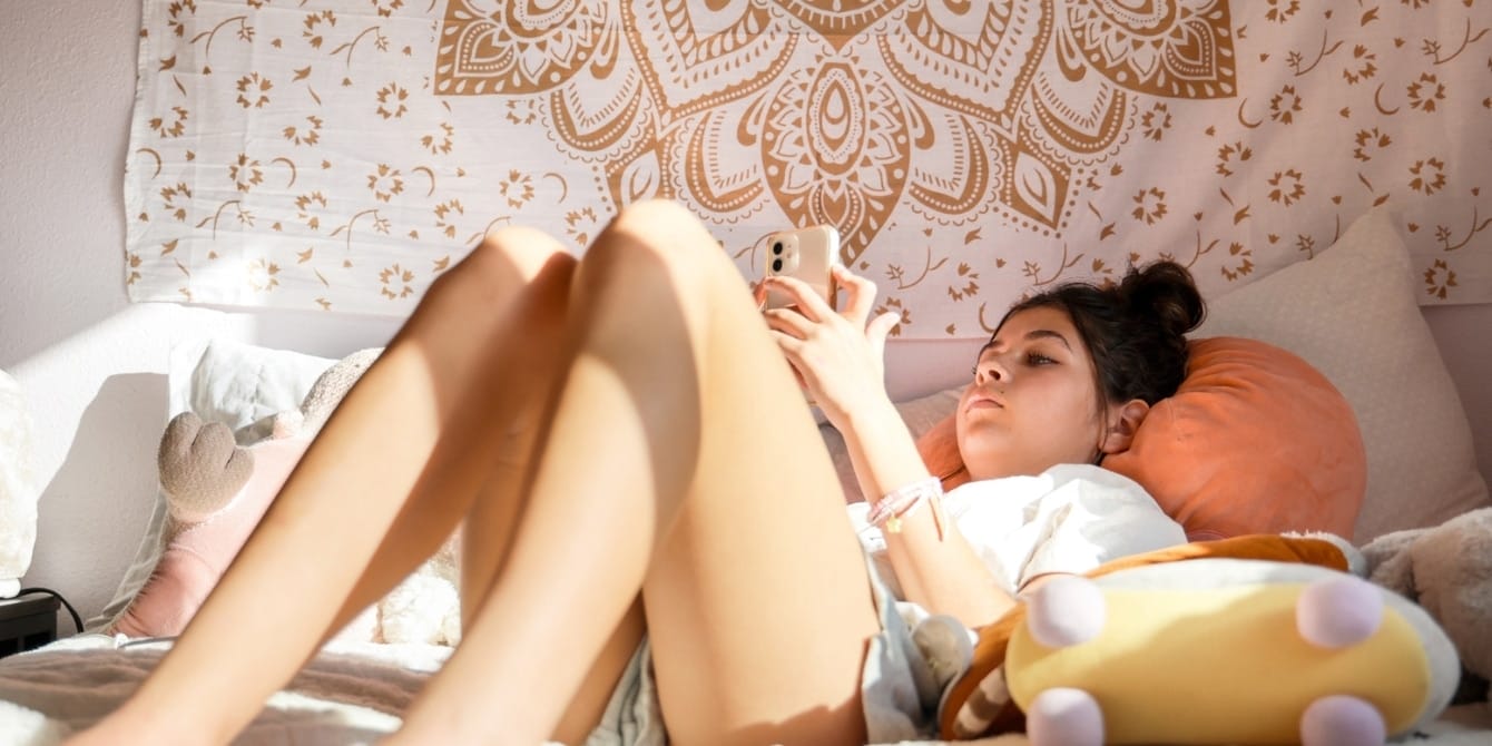 6 essential apps that will keep your tweens safe online girl in bed on the phone- safety apps