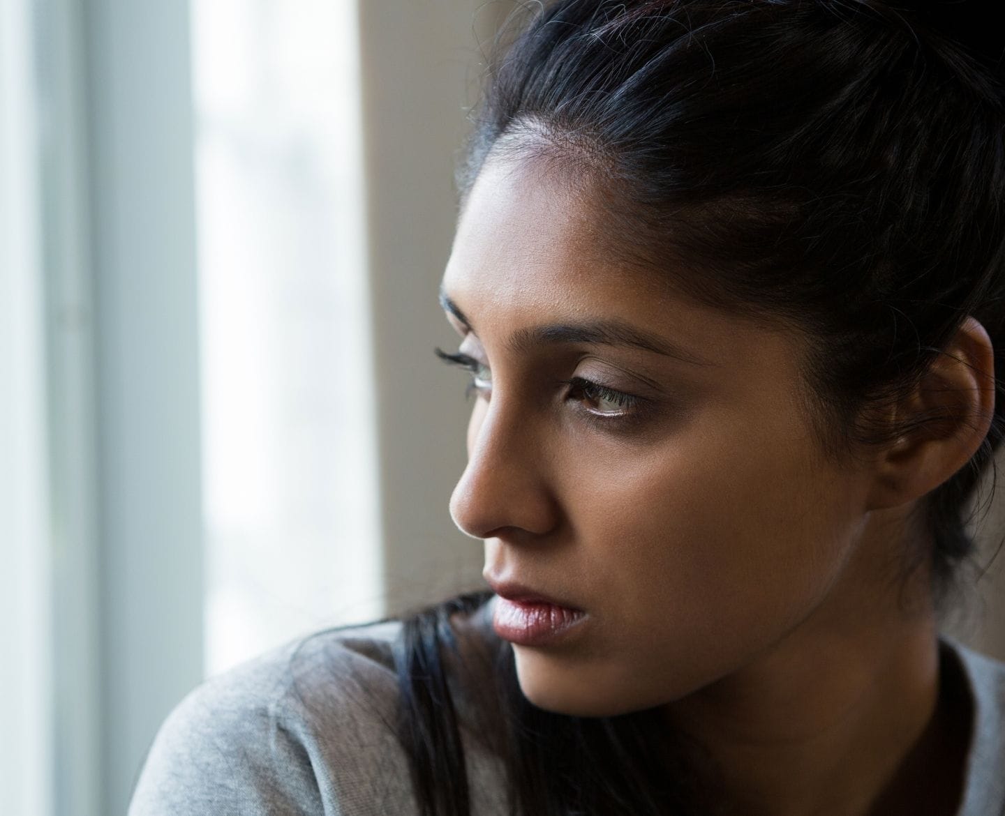Sometimes Mother’s Day is complicated—just like motherhood Mother's Day is complicated: contemplative woman looking out window
