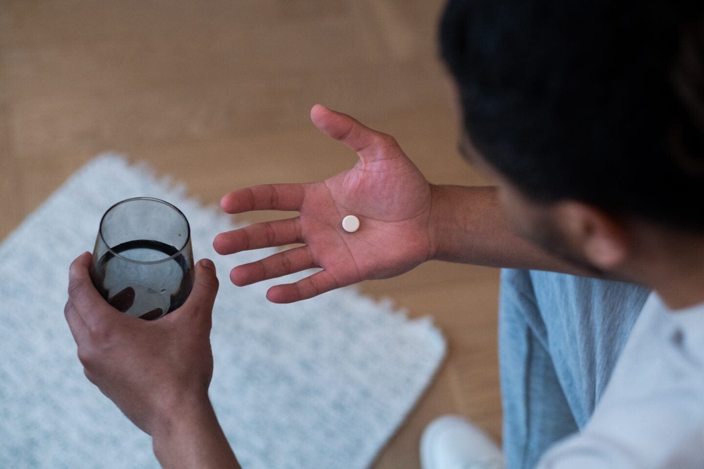 Could a real, actual male birth control pill be in our future? male birth control: man holding pill in one hand and glass of water in other hand