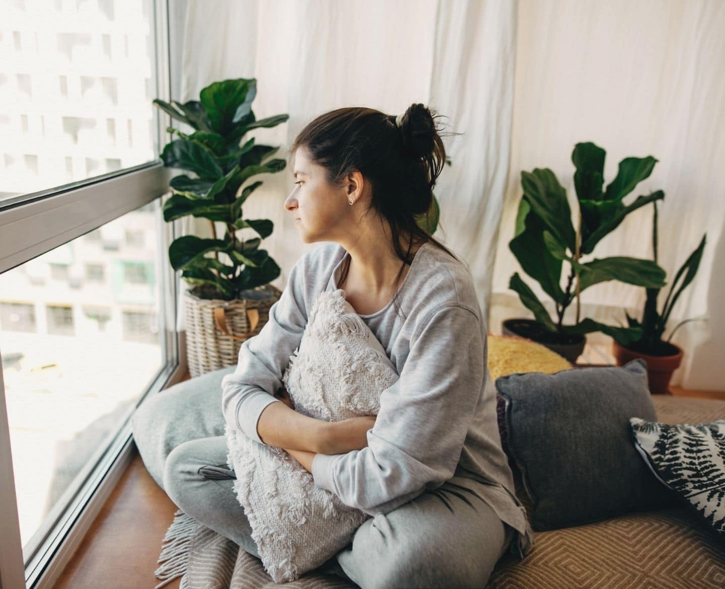 Domestic violence affects 1 in 4 women. Here’s how to spot the signs domestic violence: woman sitting alone at home looking out window
