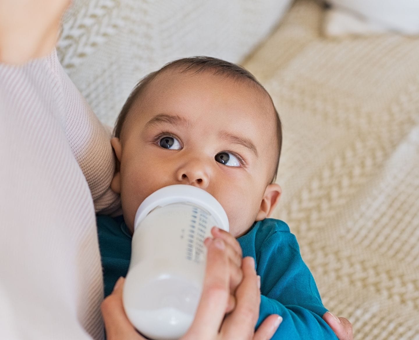 AAP warns parents against using DIY infant formula infant formula shortage: baby drinking formula from bottle
