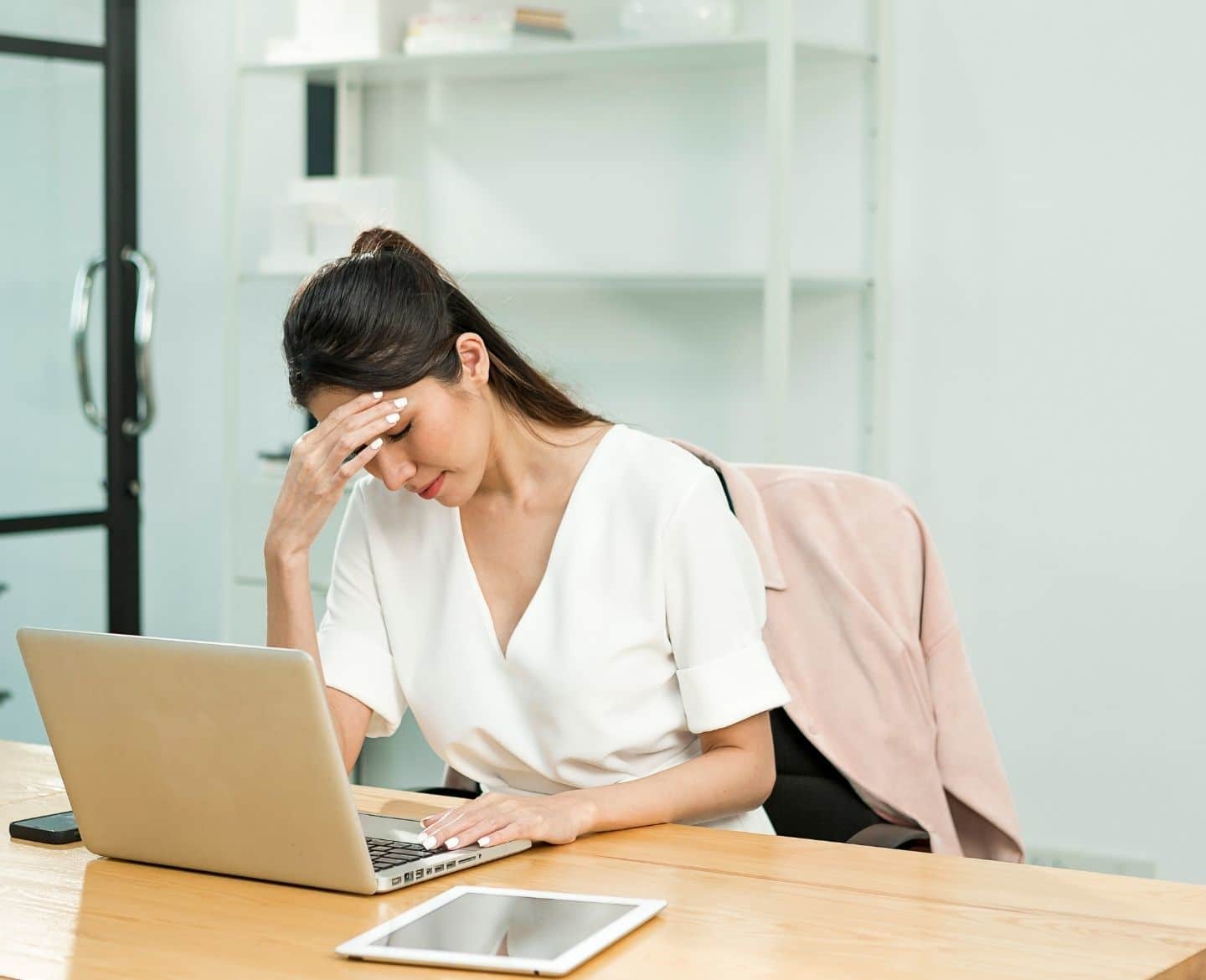 I’m a mom and the primary breadwinner—and I’m trying so hard to stop being the default parent stressed woman sitting at desk with laptop open