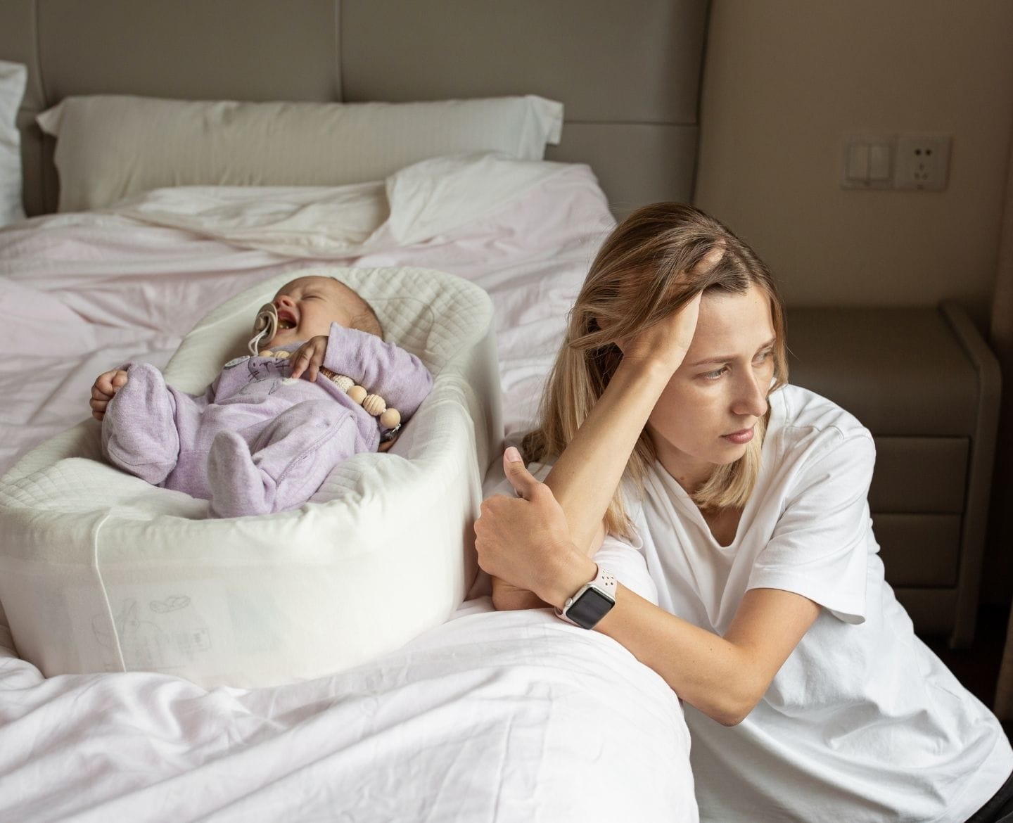Why you should think before complimenting a new mom on her weight loss baby crying, sad mom sitting beside her