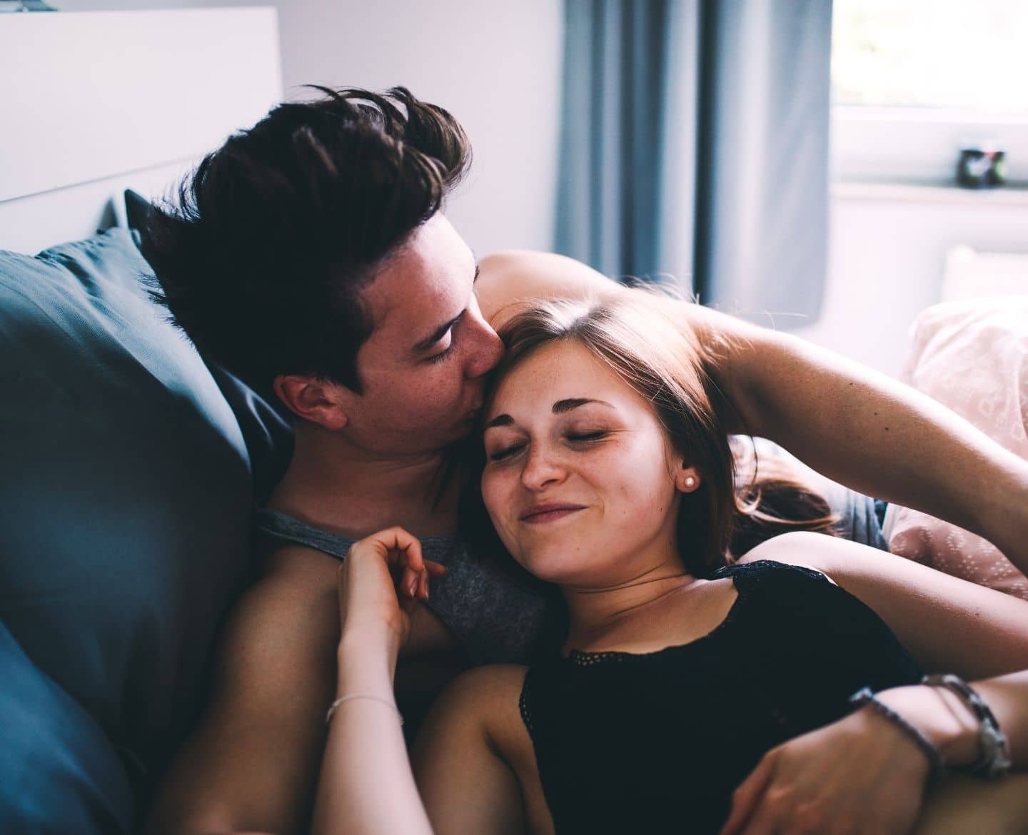 Sex after kids: You’ll have less, then more, then less—it’s all normal affectionate couple in bed - sex after kids