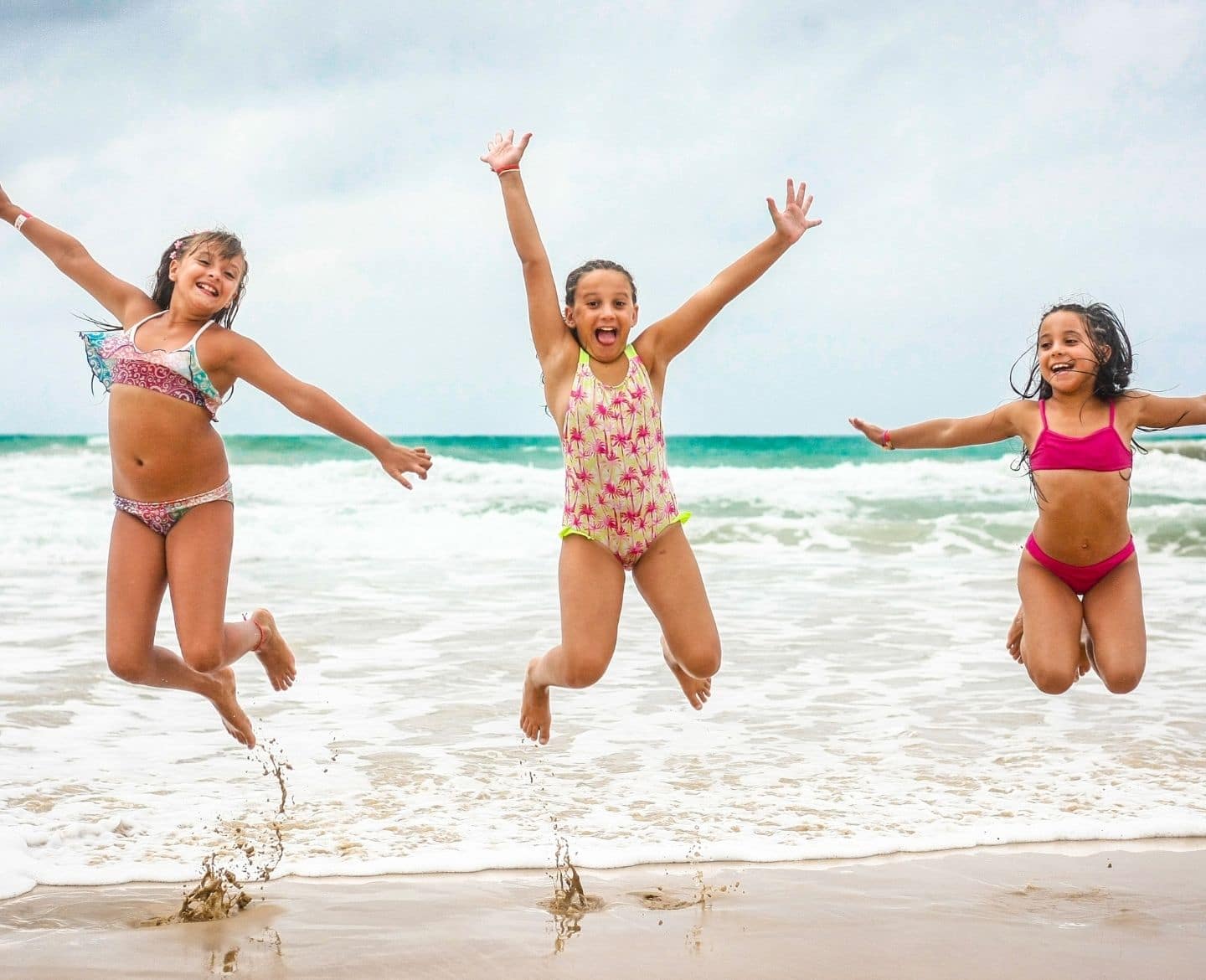 The 5 best all-inclusive Club Med family resorts 3 girls jumping on a beach