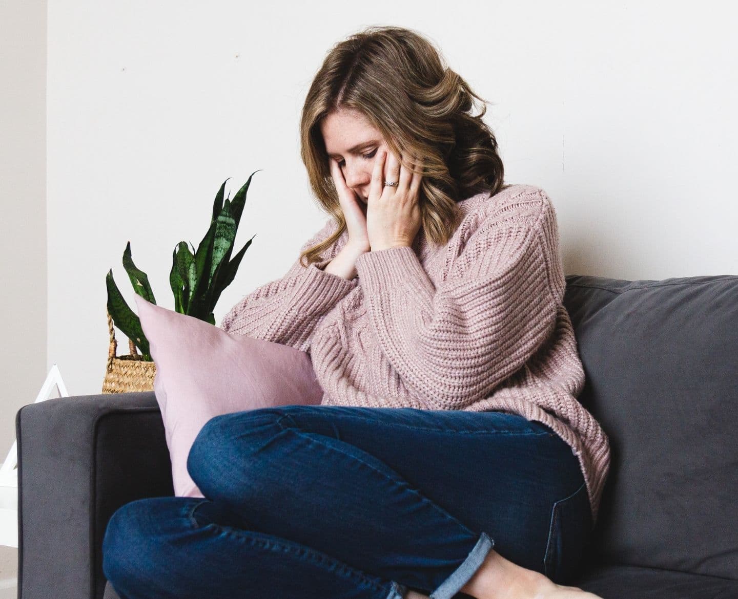 This is the worst part of unexplained secondary infertility sad woman sitting on the couch - unexplained secondary infertility