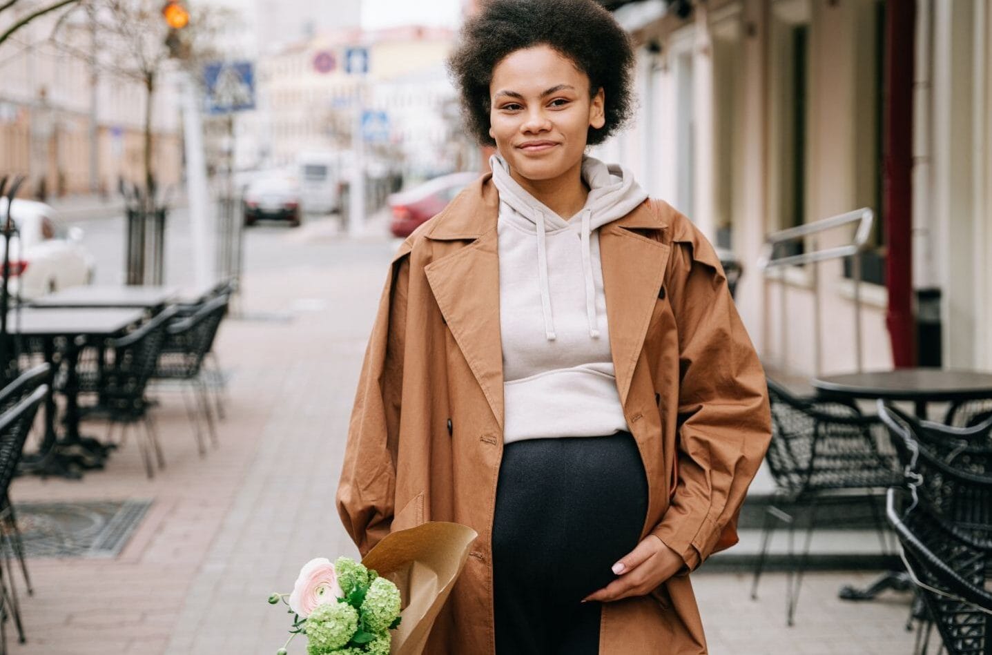 We may be able to detect gestational diabetes earlier in pregnancy, study shows pregnant woman walking in city holding flowers