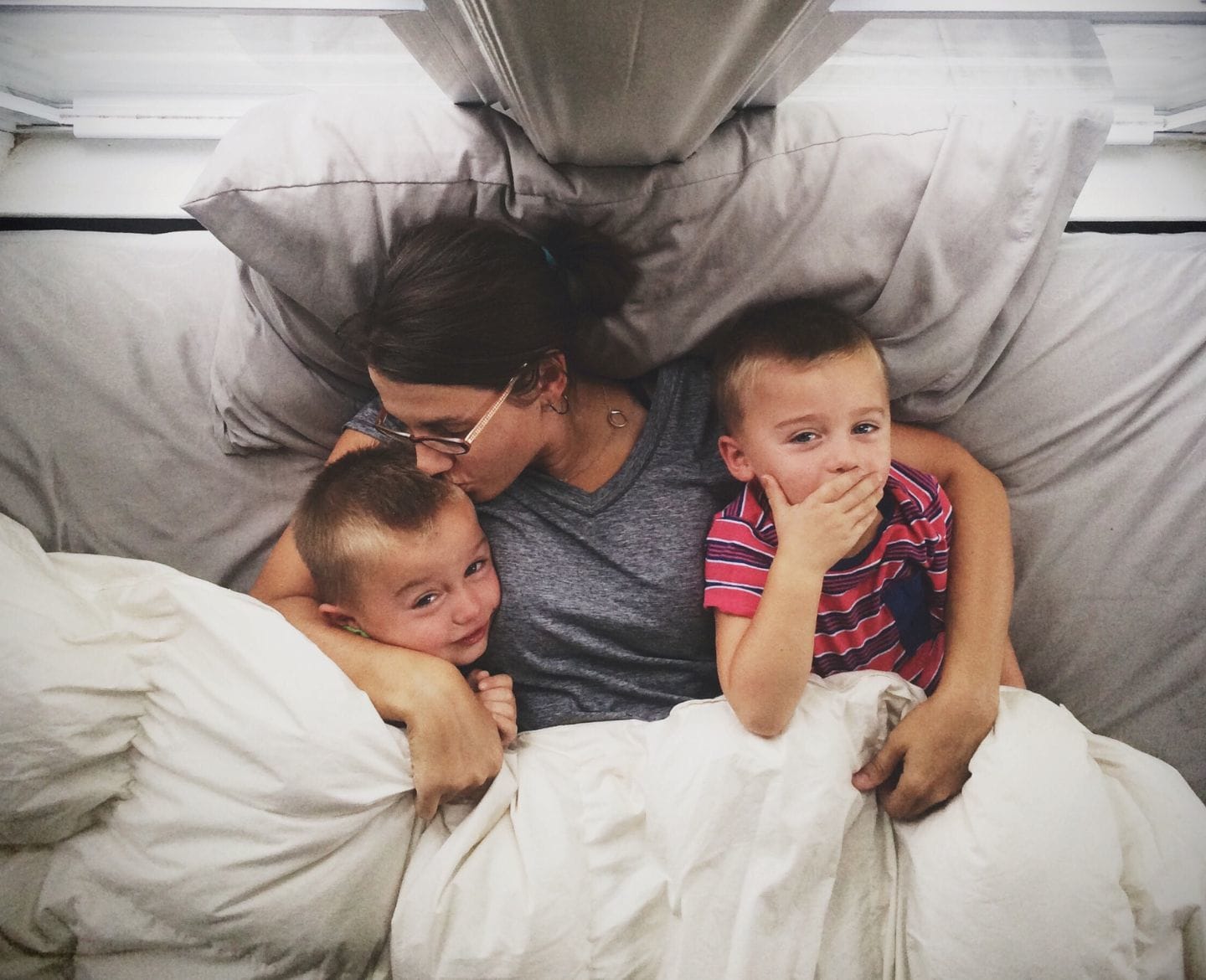 3 lessons I’ve learned raising 3 sets of twins mom kissing twin boys on the head