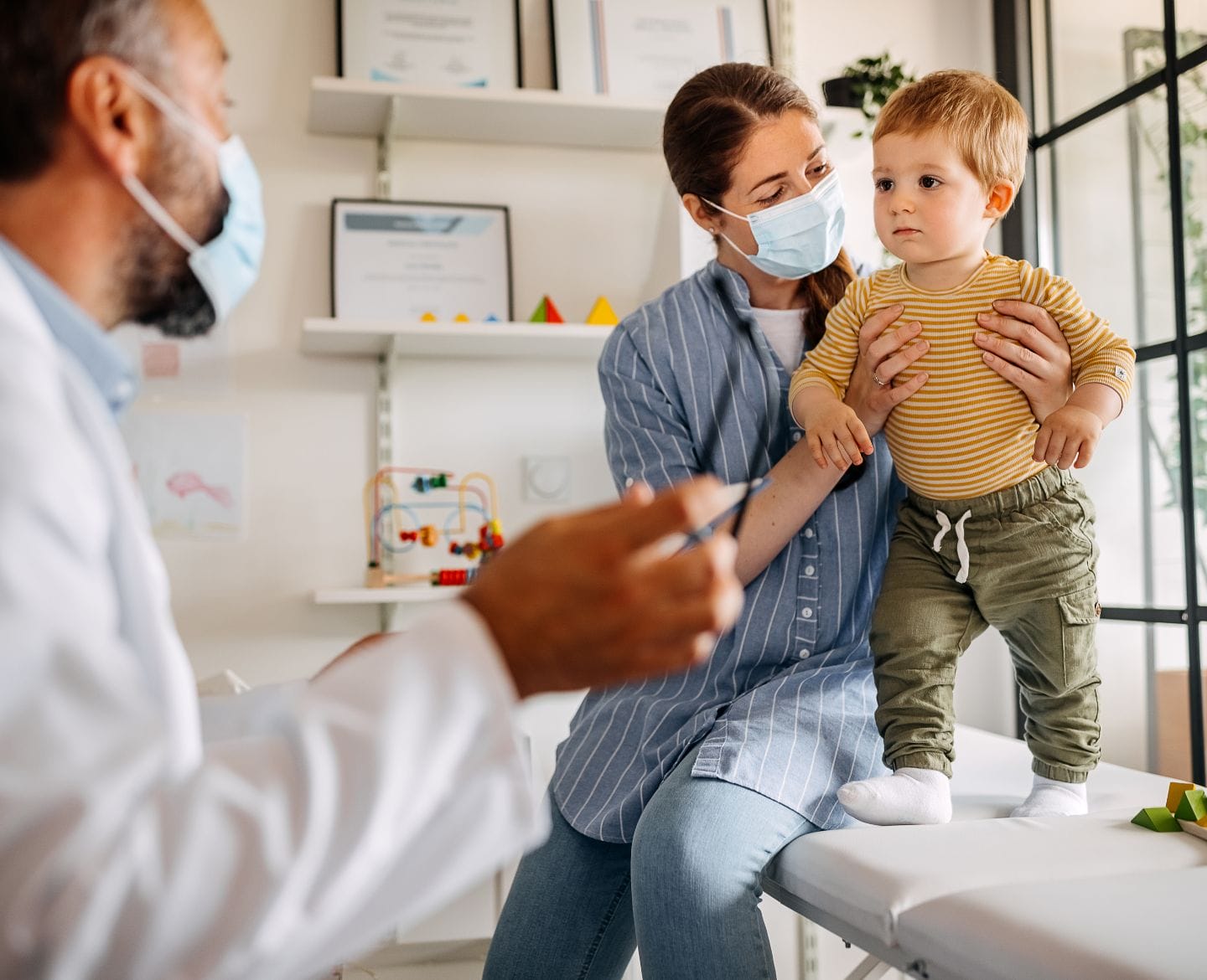 Got questions about the Covid vaccine for kids under 5? We’ve got answers Mother and baby son at doctors office for vaccine
