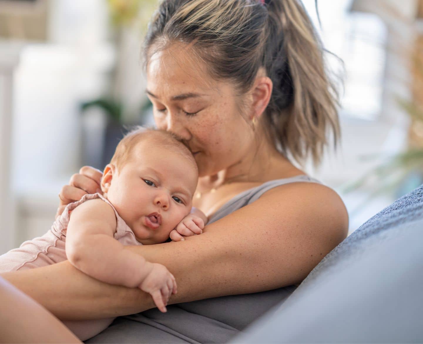 It’s time to address the lack of maternal mental health resources for AAPI moms mom kissing baby's head