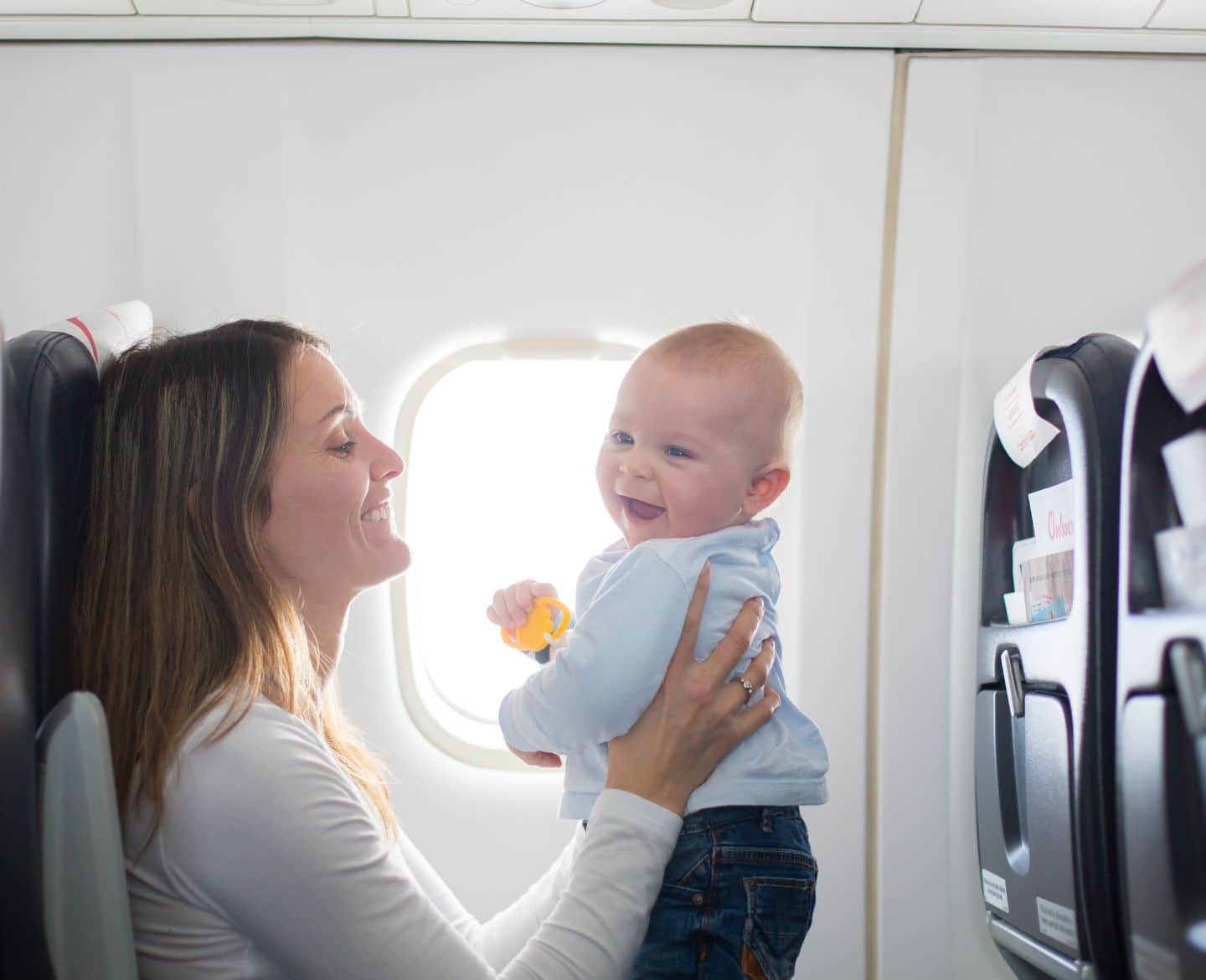 Flying with breast milk may be easier than you think mother with baby on airplane- flying with breast milk