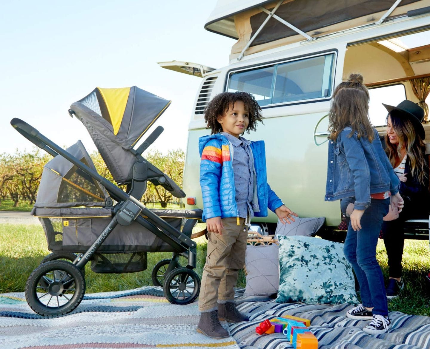 The stroller wagon that’s perfect for every family outing is also the Prime Day deal you can’t miss kids standing next to a stroller wagon and camping van - Evenflo Pivot Xplore Wagon