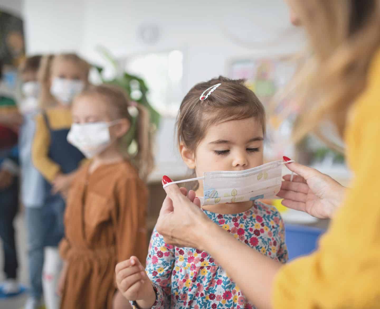 Everything parents need to know about the BA.5 subvariant Preschool girl gets help from teacher to put on covid face mask
