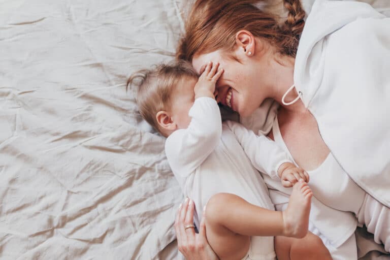 How to foster deeper connections with your baby mom and baby playing on bed - bonding with your baby