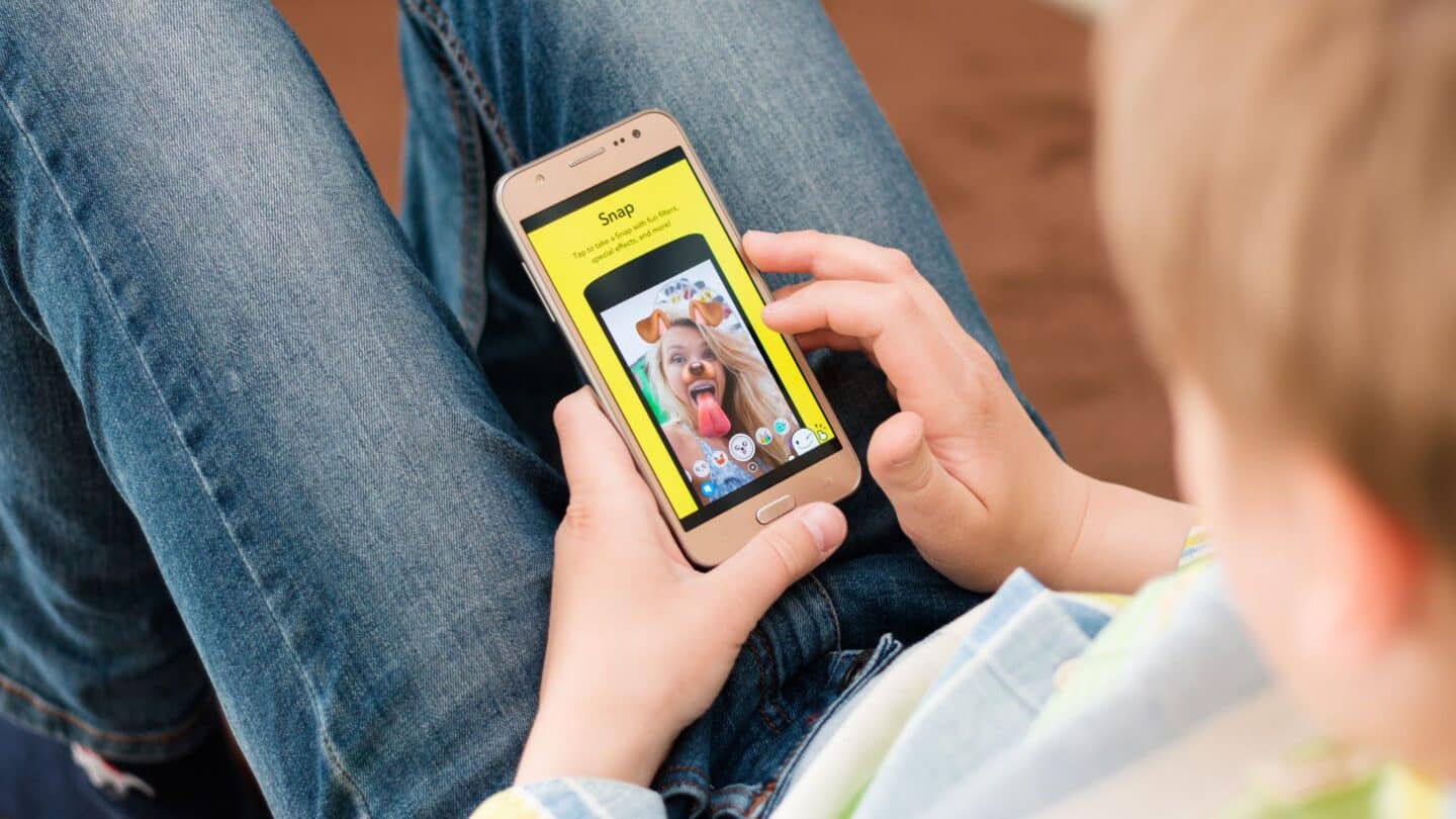 New Snapchat safety tool lets parents see who their kids are talking to Young boy using Snapchat on a smartphone