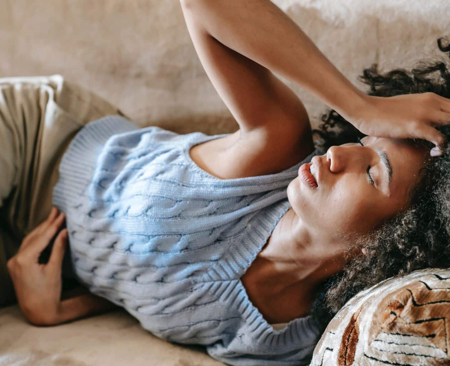 6 signs it’s time to talk to your doctor about your period symptoms woman in pain laying on couch - period symptoms