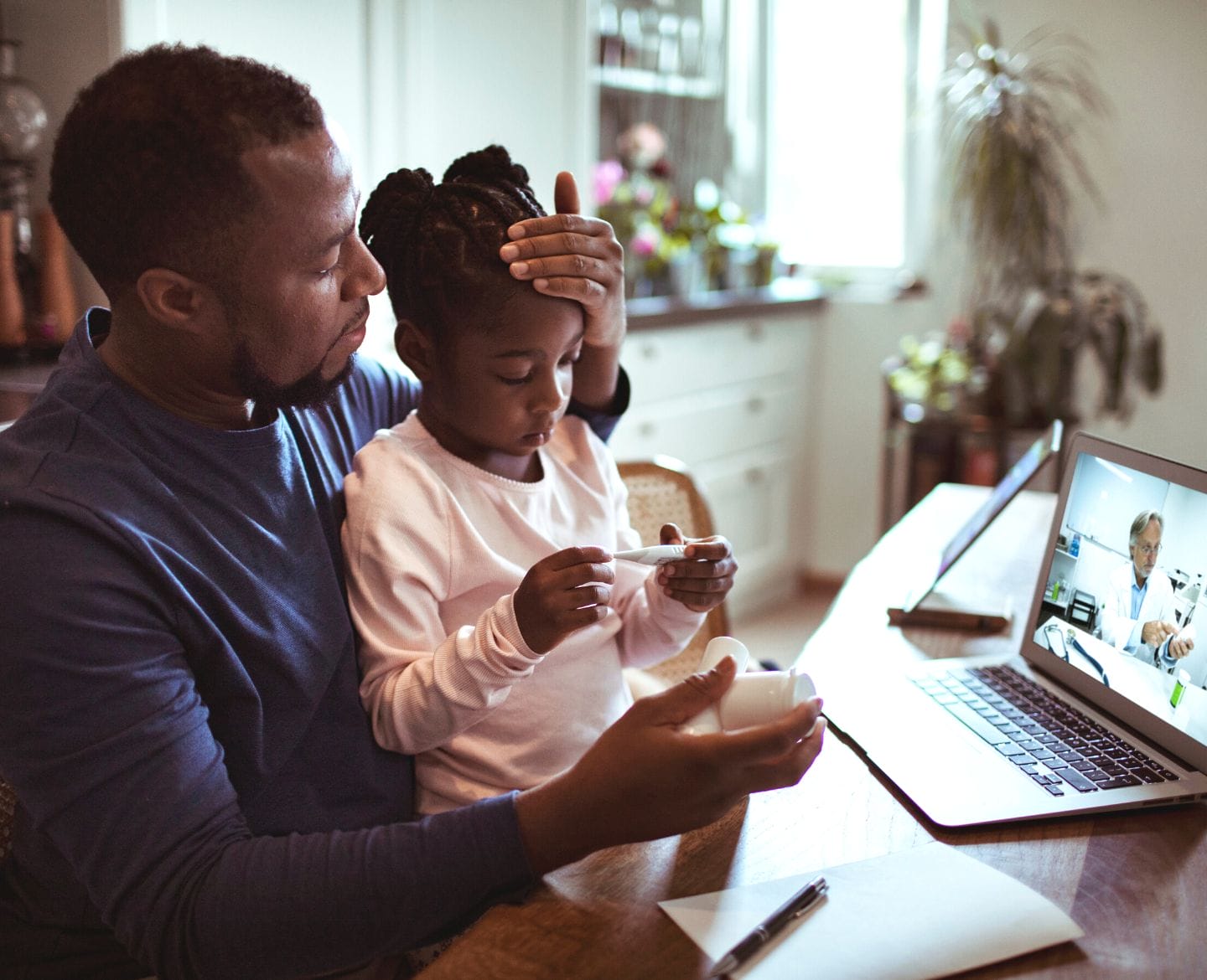 Having young kids might protect you from severe Covid, study shows father talking with telemedicine doctor sick daughter - severe covid and kids