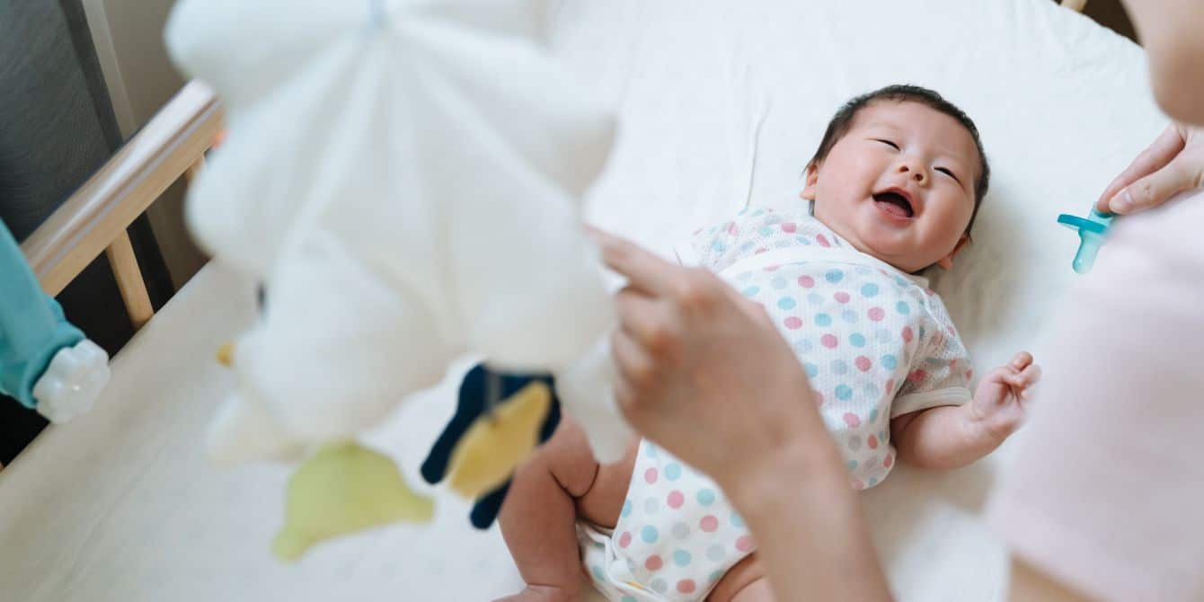 9 baby crib-in-closet ideas to inspire your small-space nursery baby smiling in a crib - crib in closet ideas