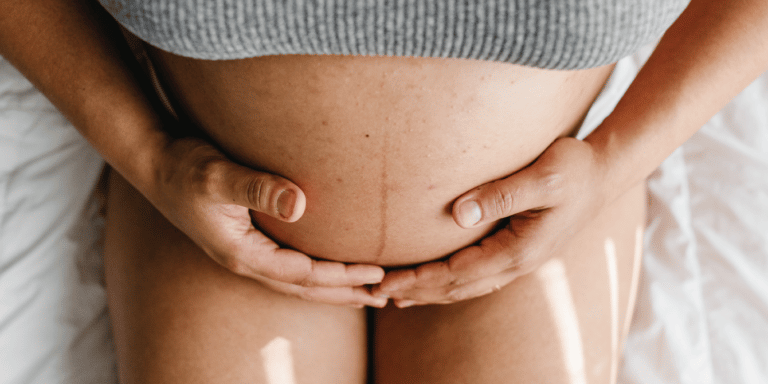 High blood pressure in pregnancy may be rising—especially among Millennial and Gen Z moms pregnant woman holding her bare belly - high blood pressure in pregnancy