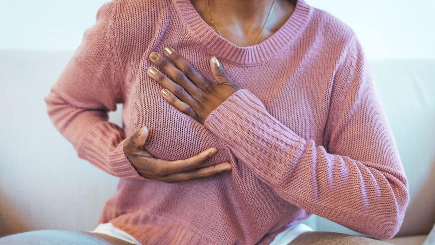 How to perform a self breast exam—and what to look out for woman performing a self breast exam