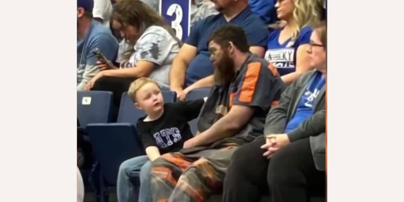 The story behind this viral photo of a coal miner dad and his son is so relatable and sweet A coal miner dad sits with his son at a University of Kentucky basketball game.