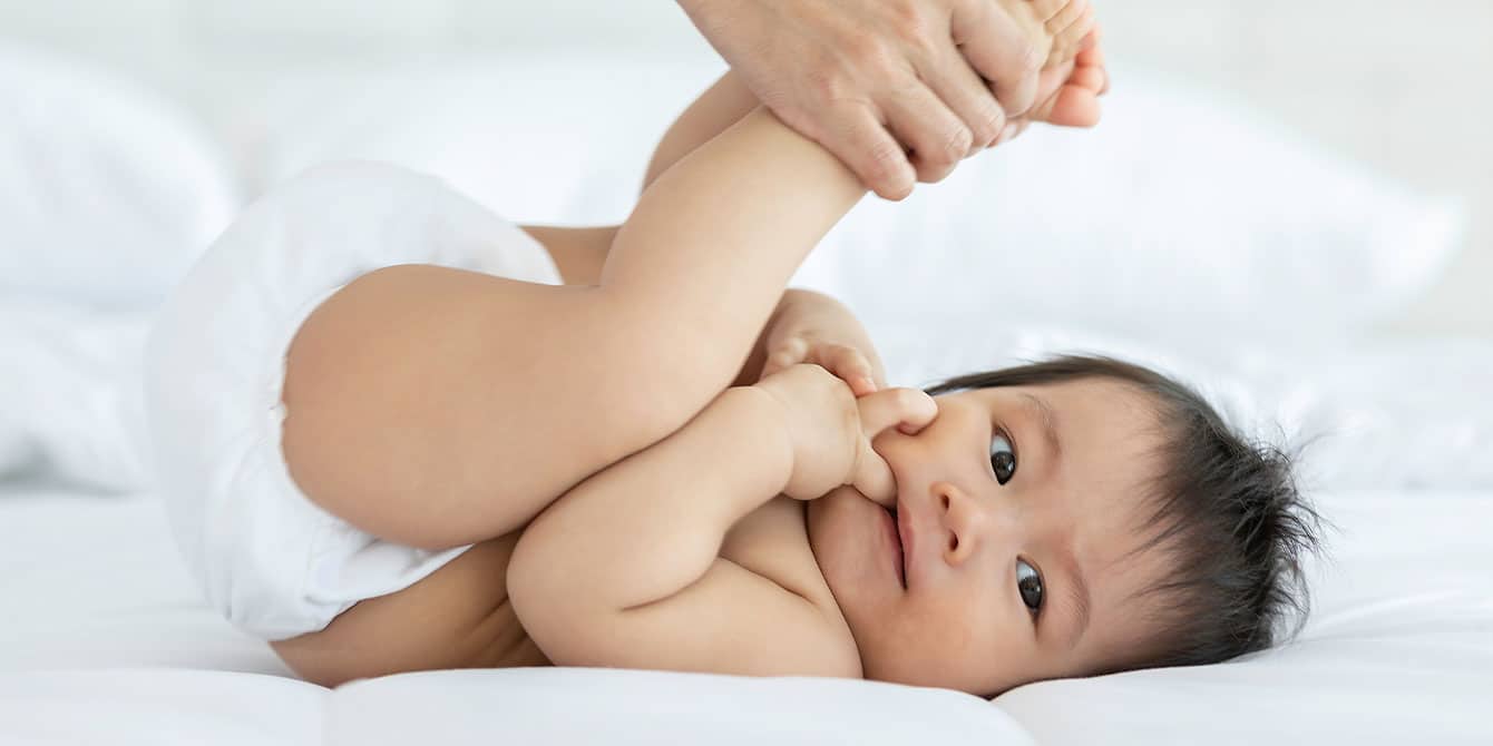 Infant massage is good for babies—and parents baby getting an infant massage at home