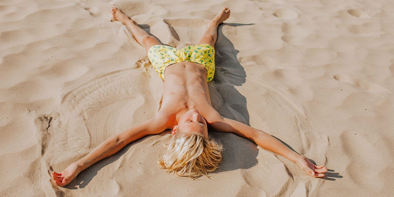 Bulzibucket and 9 other fun beach activities for kids teenager-making-sand-angels-on-the-beach- beach activities for kids