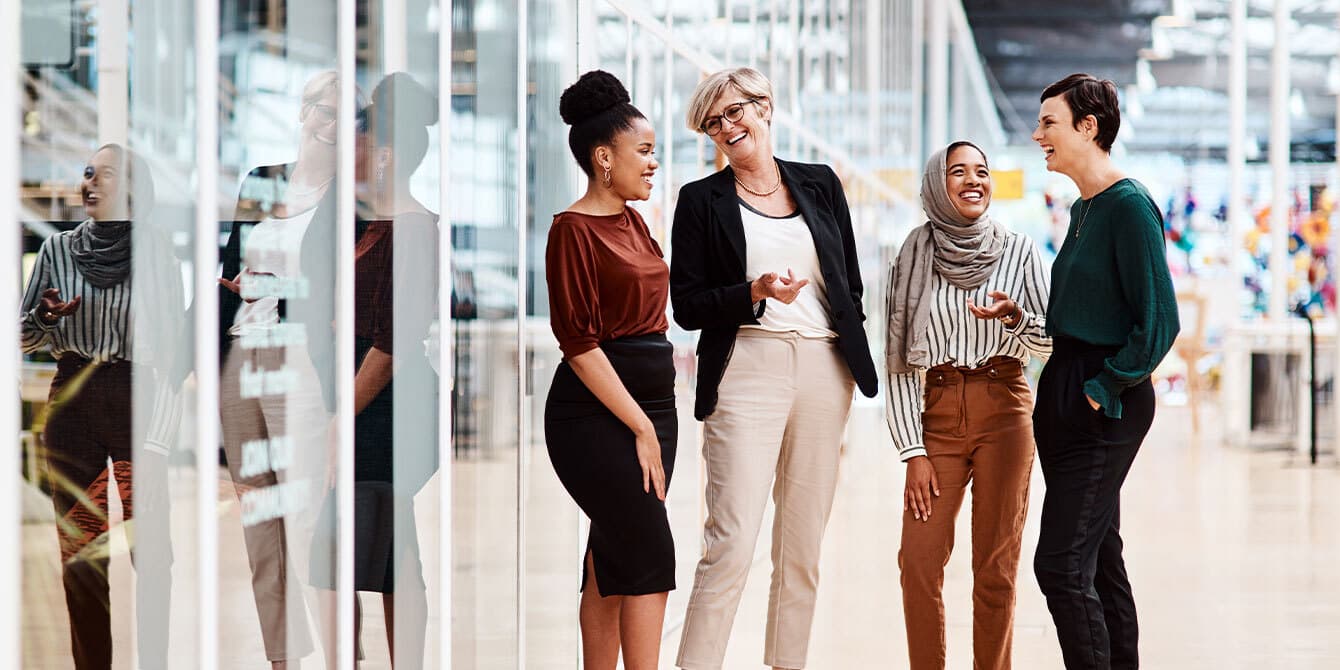 6 soft skills that will get you promoted faster than hard work can, according to a career coach women in an office talking and displaying soft skills and interpersonal skills
