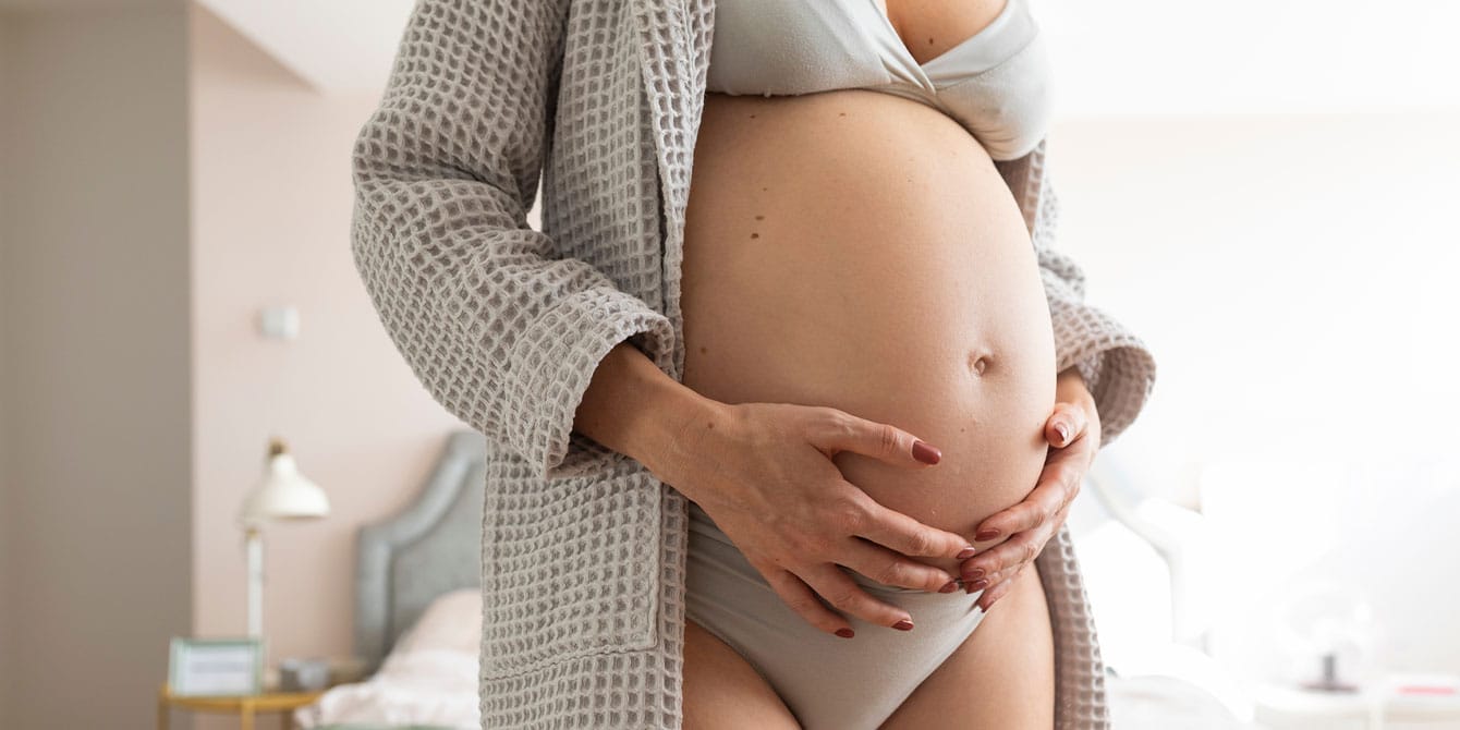 It took until week 27 for my bleeding during pregnancy to resolve, but my son is perfect woman holding her pregnant belly wondering about bleeding during pregnancy