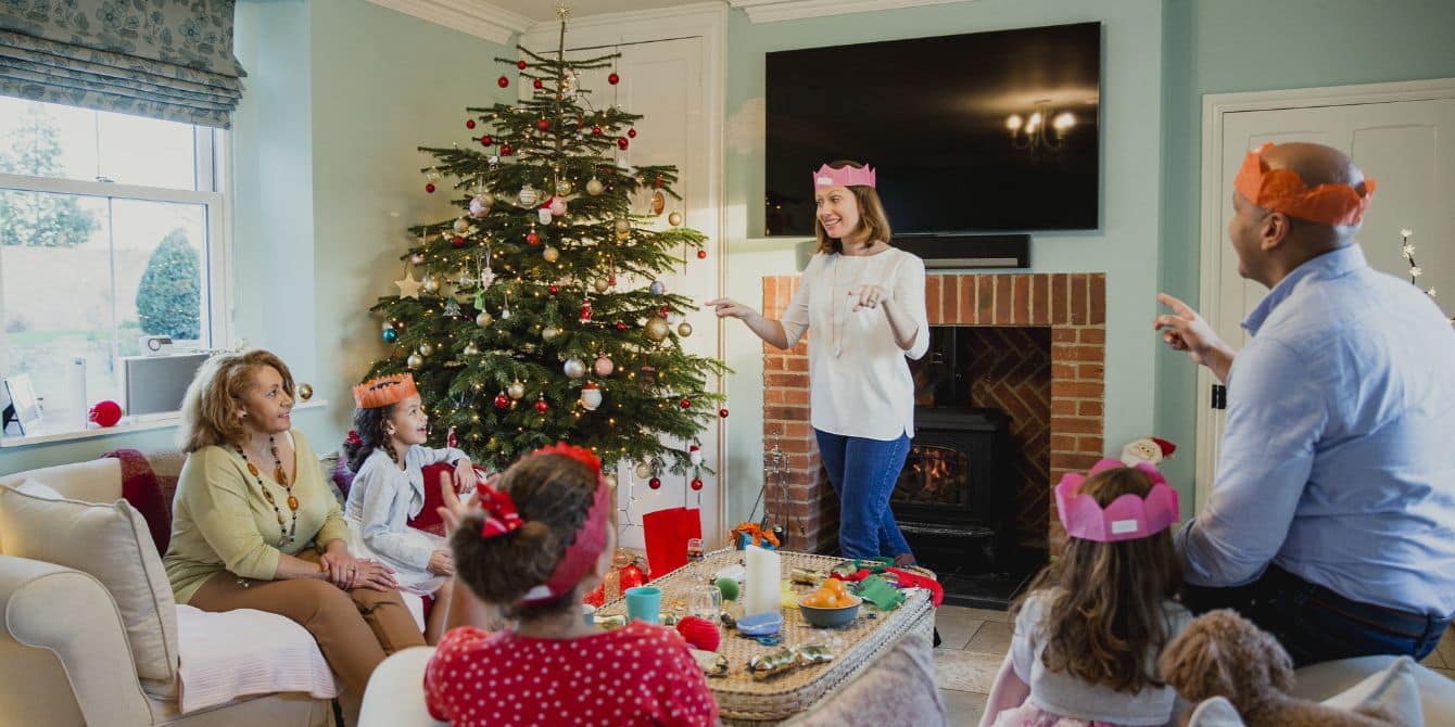 Gather around the tree for these 10 entertaining Christmas games for kids family playing games by christmas tree-christmas games for kids