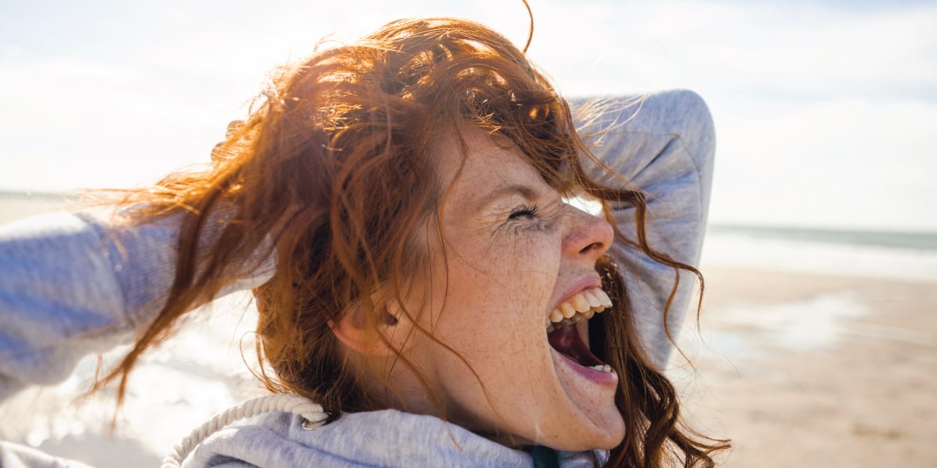 Feeling stressed? Why experts say scream therapy might be the self-care you’re missing Woman at the beach screaming in scream therapy for self-care