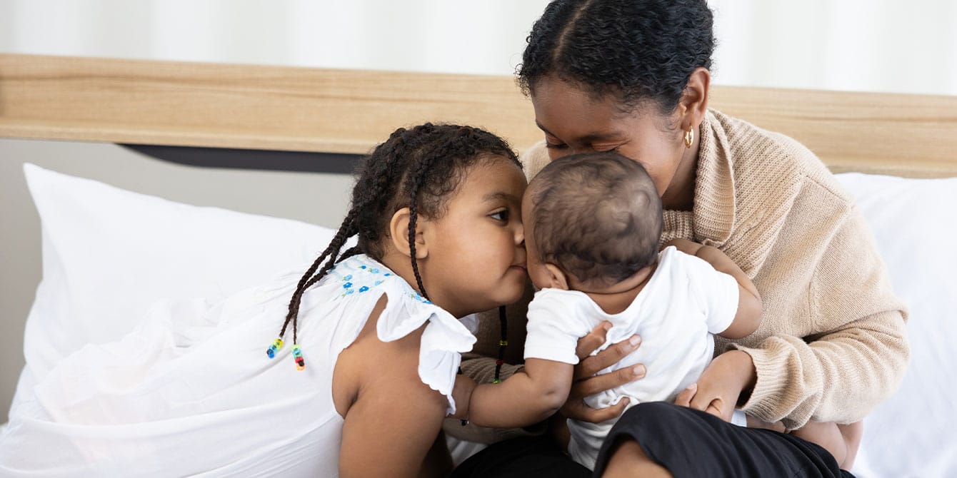 What parenting with a severe mental illness looks like mom parenting and cuddling child and baby on a bed