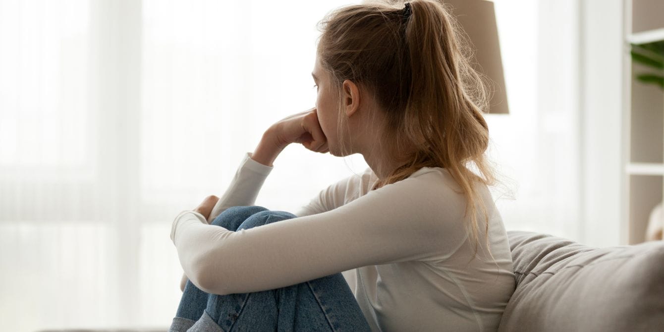 Birth control linked to higher rates of depression in teens with ADHD sad teen at home on couch looking away - birth control and depression