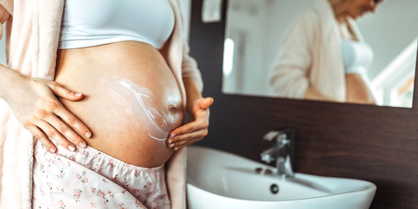 Researchers find a chemical link that could help predict the risk of preterm birth pregnant woman applying cream to her belly - preterm birth linked to chemicals