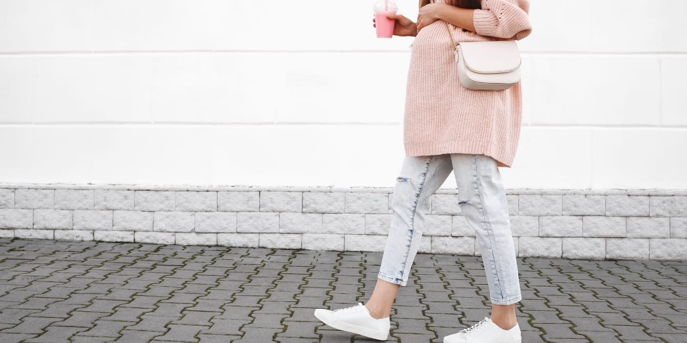 Does curb walking induce labor? Here’s what experts want you to know pregnant woman walking down the street - curb walking to induce labor