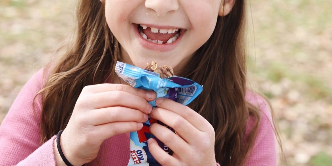 10 of the best store-bought snacks for kids girl holding snack bar- store-bought snacks