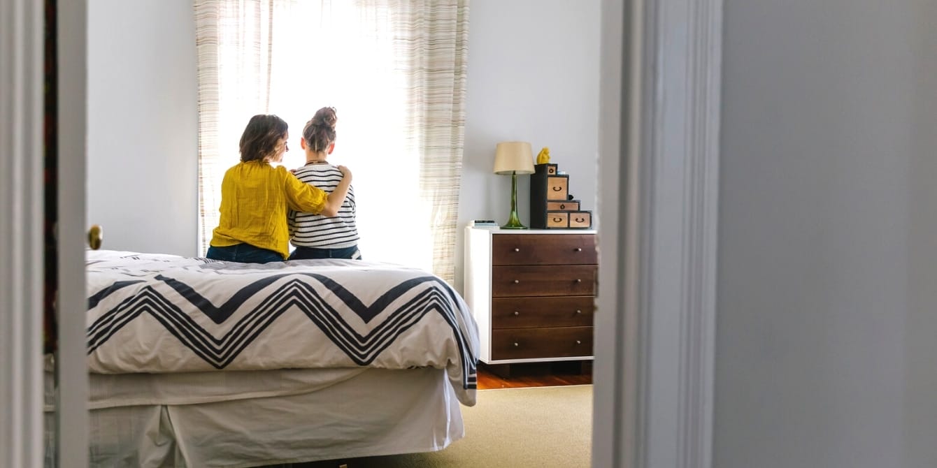 Talking to teens about suicide and self-harm can save lives mother comforting daughter at home on bed - how to talk to teens about suicide