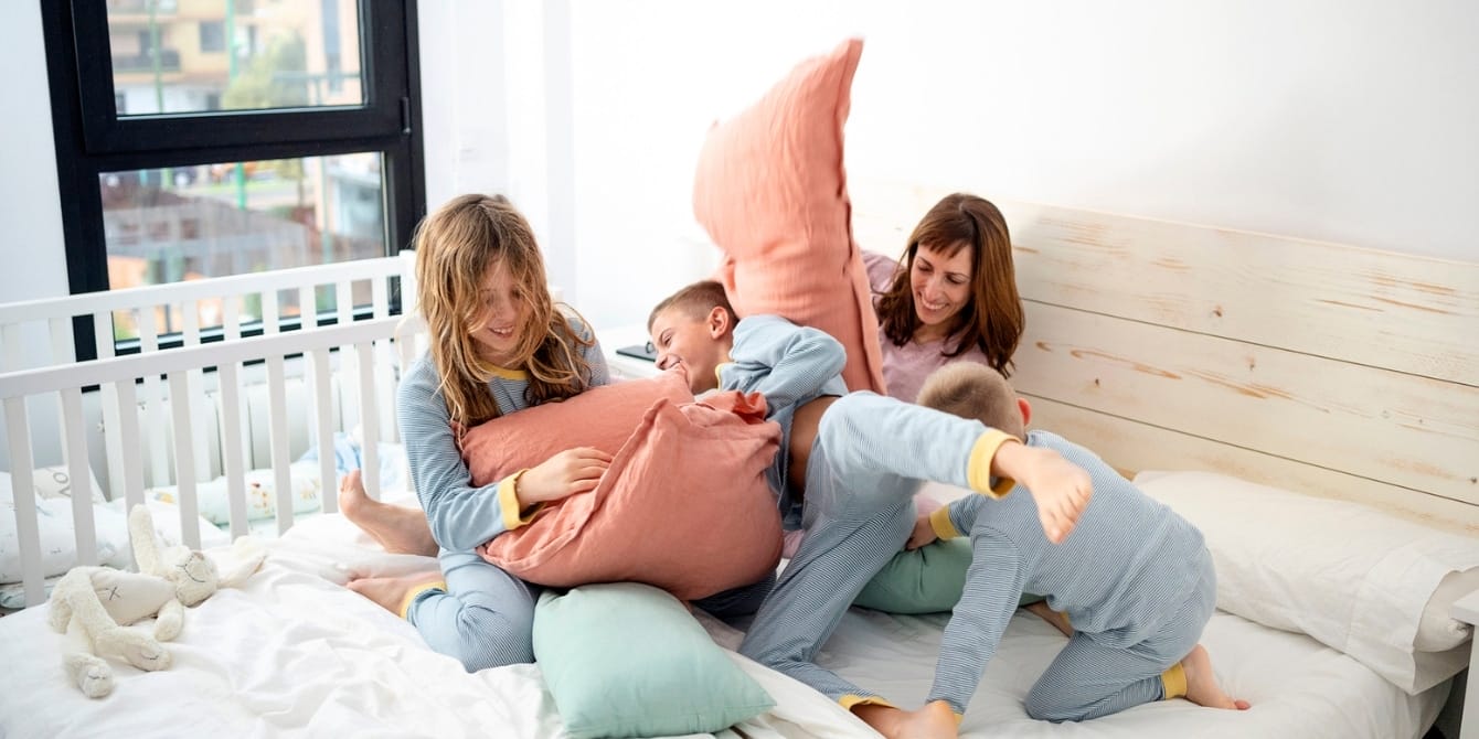 10 fun ways to spend Mother’s Day with the whole family mom and kids having a pillow fight- mother's day activities