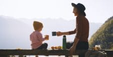 12 ways to have an eco-friendly Mother’s Day mom and child cheers with mugs on a park bench