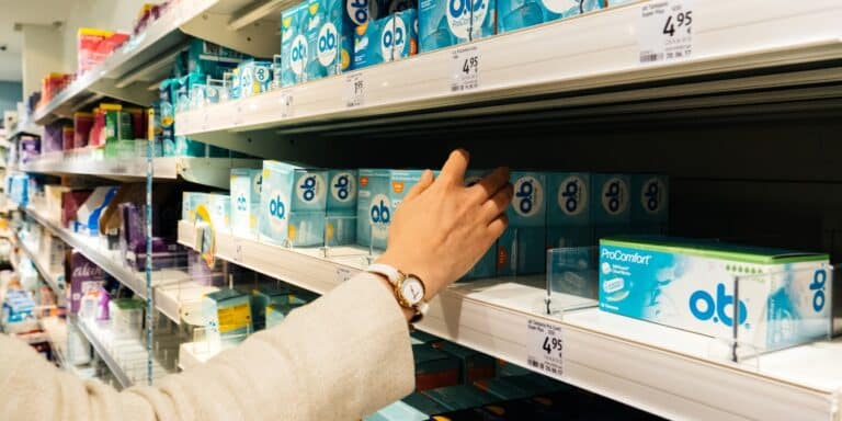 New data reveals the troubling reason tampons have gotten so much more expensive woman's hand picking up a box of tampons from a store shelf