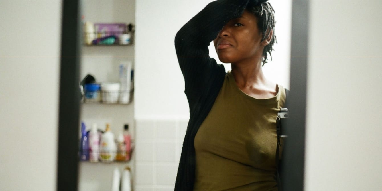 I turned to photography in my darkest moments & it helped me heal woman looking in mirror with postpartum depression using photography to help her cope with the postpartum period