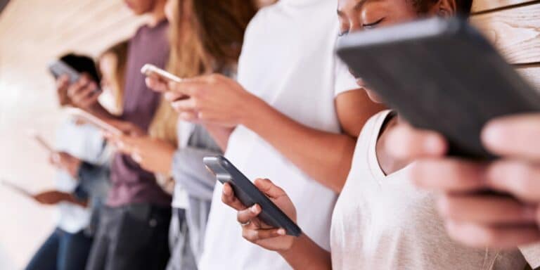 APA releases new guidelines on teen social media use: What parents need to know group of teens using smart phones - apa guidelines on social media