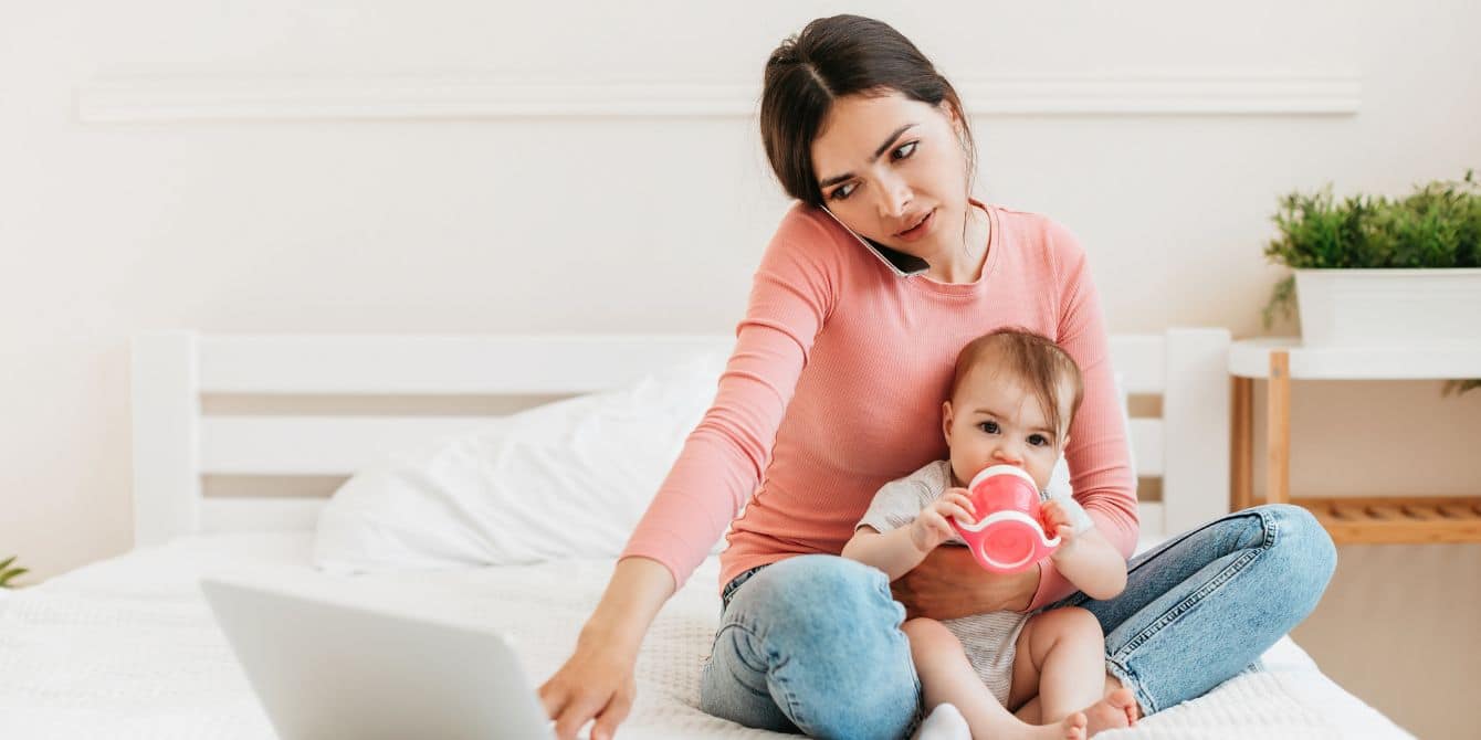 This Reddit post about a mom wanting a solo vacation is BONKERS mom on the phone working with babe on her lap- mom's post about wanting a solo vacation