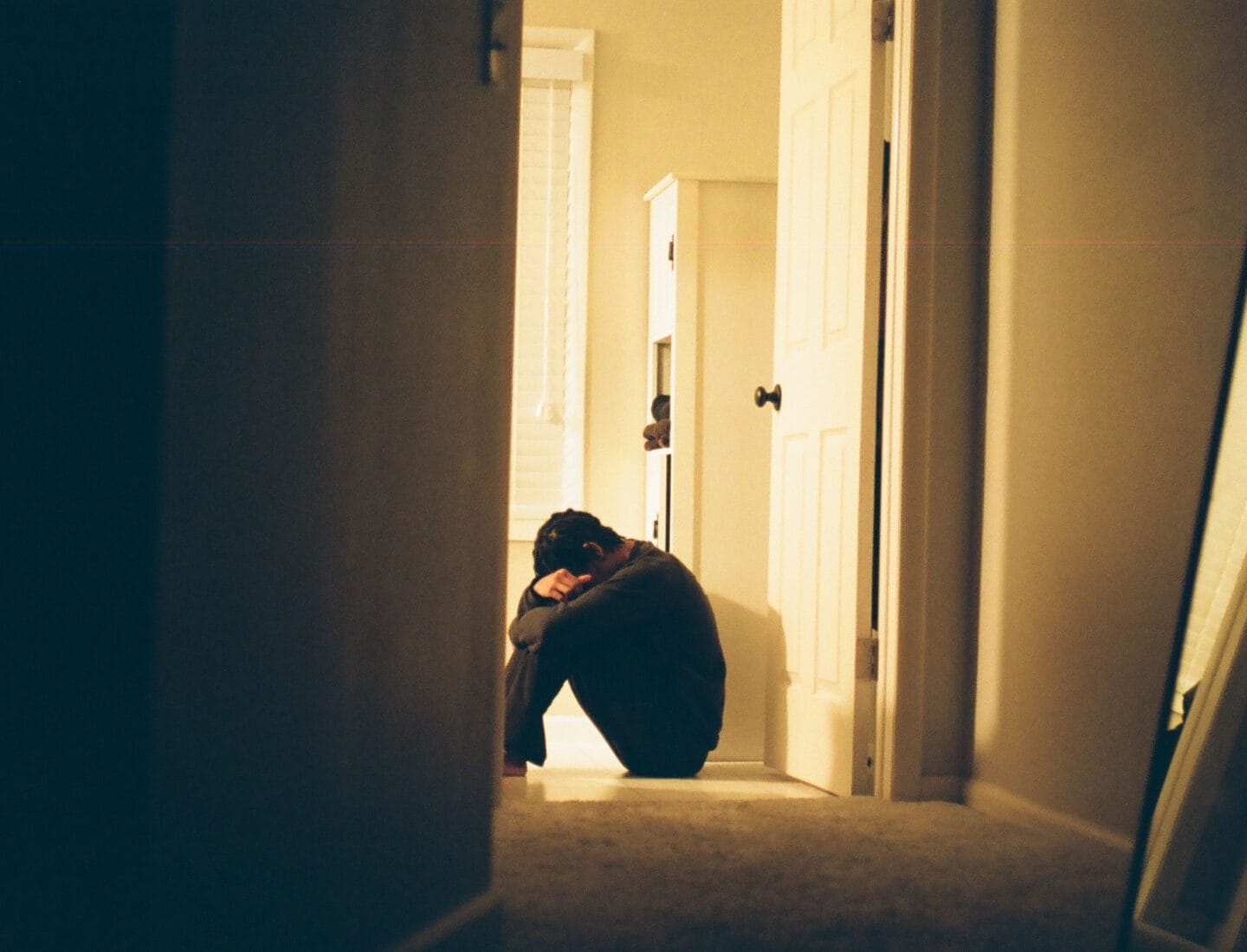 sad parent crying on floor - Motherly